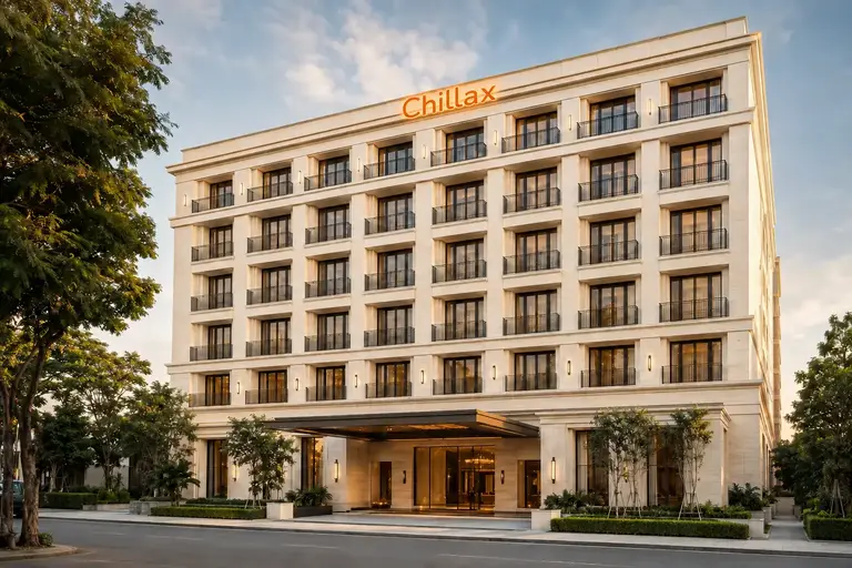 Seven-storey ivory contemporary modern boutique hotel with an illuminated orange Chillax rooftop sign